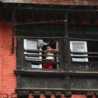 窓から雨を眺める子ども